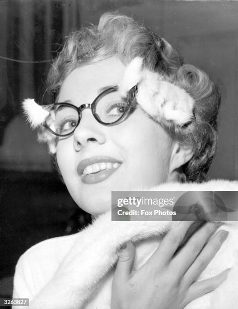 Model Jean Clarke wearing a pair of ermine trimmed glasses to complement her mink stole.