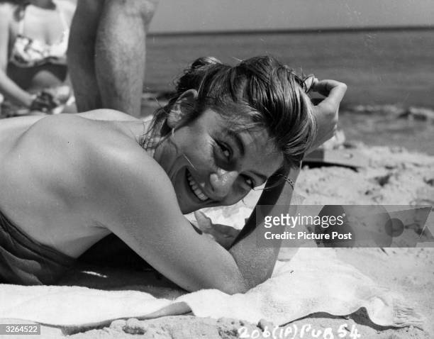Anouk Aimee,, the film actress takes in the sun on the beach