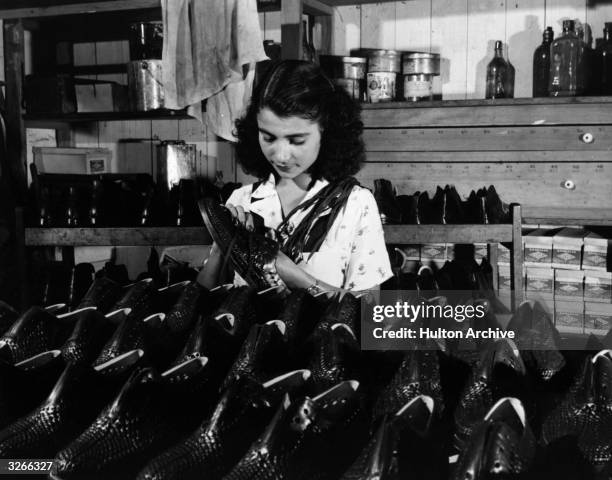 Young girl shines shoes at a shop in Peru.