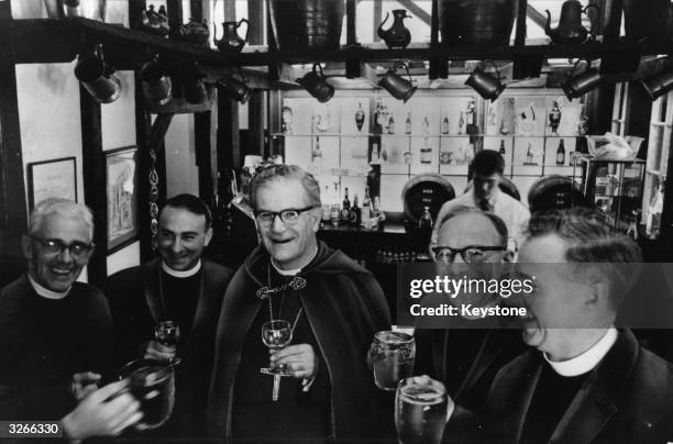 Group of four newly-appointed clergymen enjoy a drink with the Bishop of Southwark at a local pub.