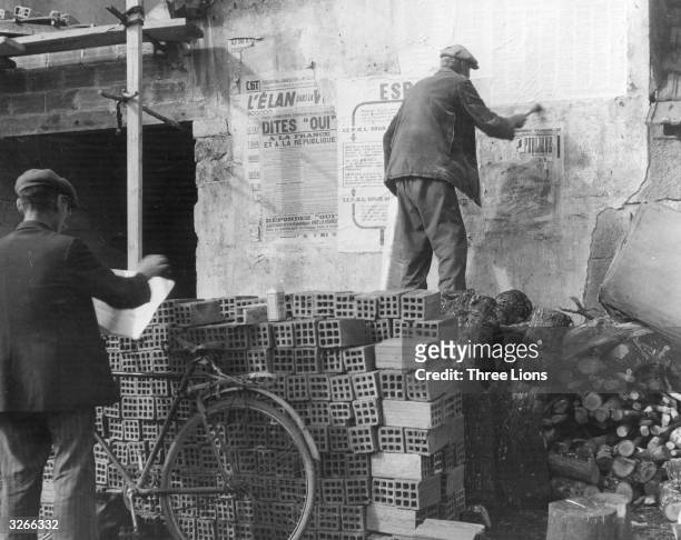 Man prepares to put up an election poster in the French village of Rungis.