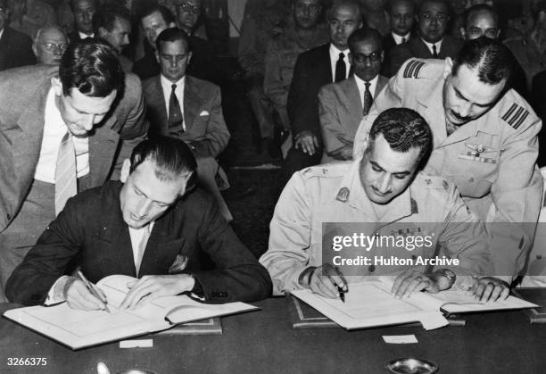 Egyptian Prime Minister Gamal Abdul Nasser and British minister of state Anthony Nutting signing the Anglo-Egyptian Agreement in the Pharaonic Hall...