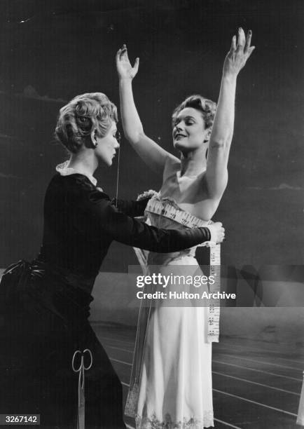 Anna Neagle formerly Marjorie Robertson, the British leading lady who married the director Herbert Wilcox. She is being fitted for a dress in...