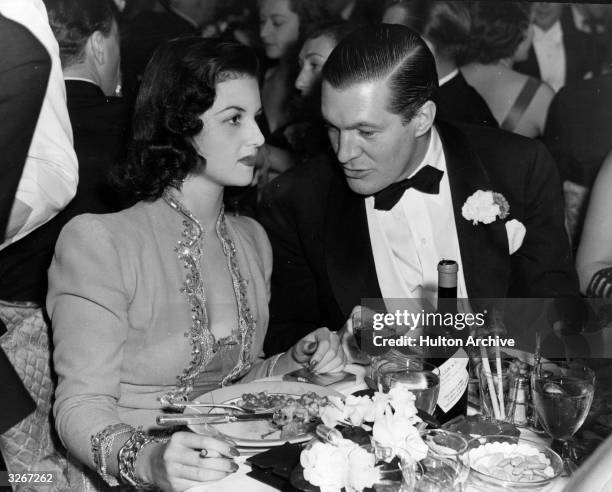 Brenda Frazier, elected as America's no.1 glamour girl, dines at a New York nightclub with Peter Arno , famed comic artist.