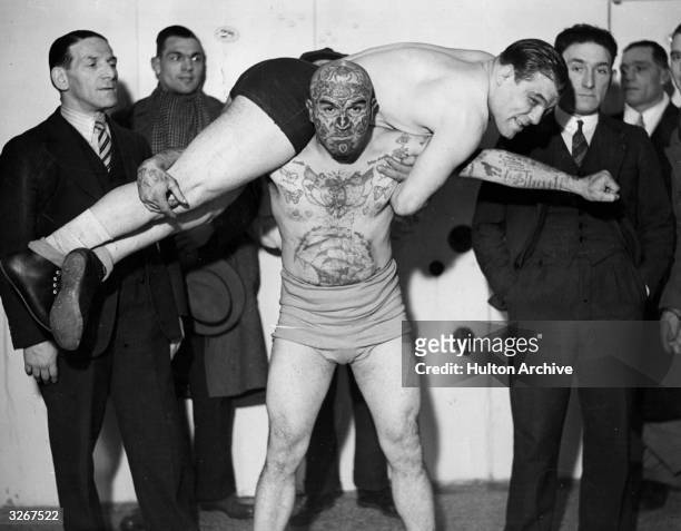 Jacobus Van Dyn, known to Londoners as the 'Tattoo Man' and lecturer, tries out a few holds in the dressing room at the Manor Place Baths before a...