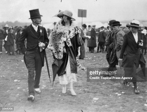 Major and Mrs Hedges stride purposefully about in their finery at Ascot.