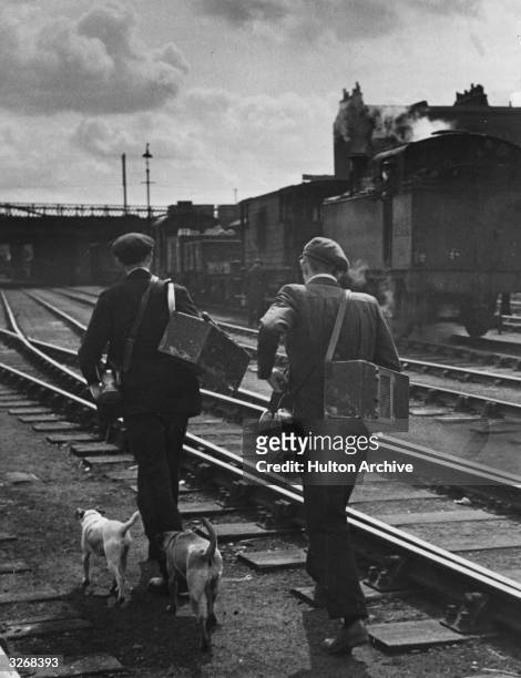Railway rat catchers walk along the track.