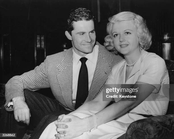 British actress Angela Lansbury with Peter Shaw on their arrival at London Airport before their wedding.