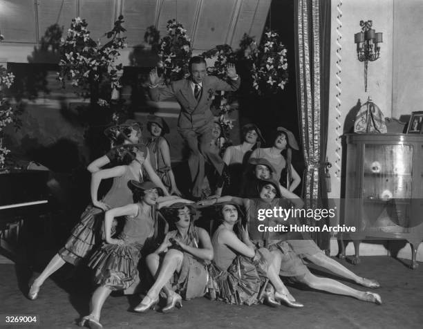 Dancer doing the Charleston surrounded by chorus girls.