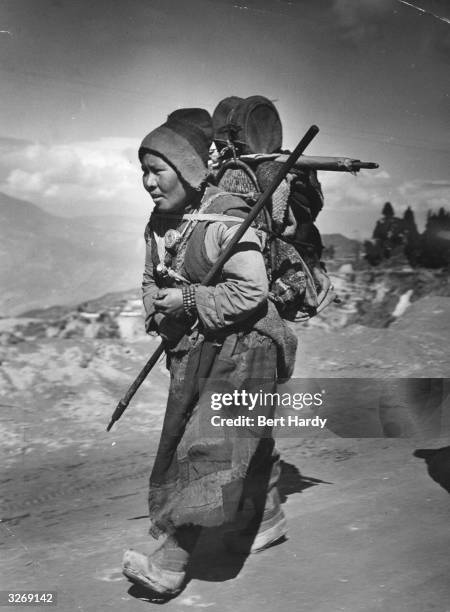 Tibetan refugee, carrying all her belongings on her back, makes her way to freedom across a 14,000 foot high pass, following Chinese oppression in...