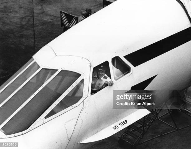 Captain Brian Walpole smiles from the cockpit of Concorde, having arrived from London on its first commercial flight to New York, 22nd November 1977.