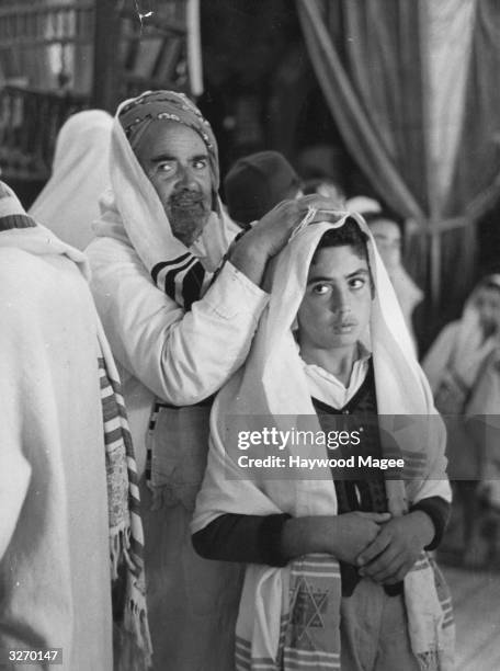 Jewish boy and an older man visit a synagogue on the island of Djerba or Jarbah off eastern Tunisia, for the ceremony of Simchat Torah, the Festival...