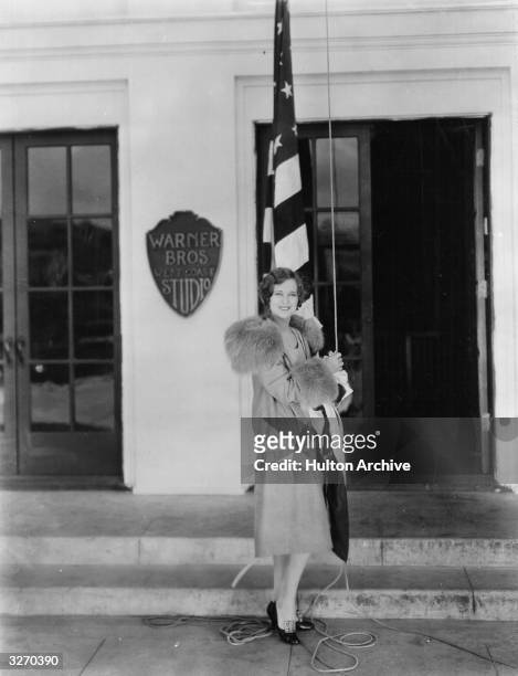 Dolores Costello the American silent screen heroine who worked for Warner Brothers. She is outside the studio, about to raise the flag known as 'Old...