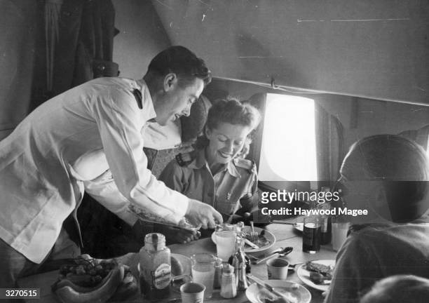 British film actress Winifred Shotter and Jack Lester have lunch at 6,000 feet during their flight to India. Original Publication: Picture Post -...