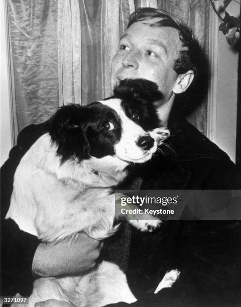 Pickles, the dog who found the stolen World Cup when out for a walk with owner David Corbett in Norwood, south London, being held by Corbett.