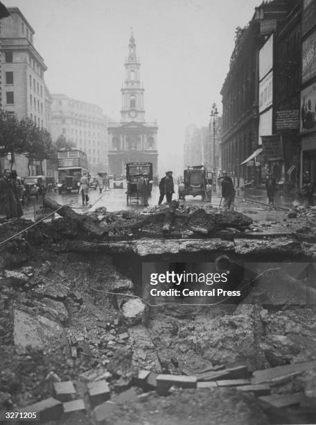 Huge hole in the Strand, where a bomb was dropped during an air raid over central London. It fell near the Gaiety Theatre and the church of St....