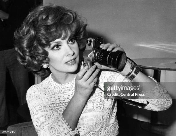 Italian actress Gina Lollobrigida and her camera at a press conference in London for the launch of her book of photographs 'Italia Mia'.