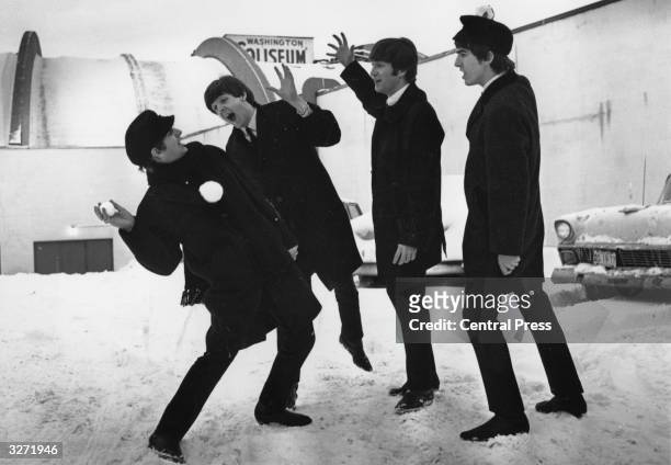 The Beatles soon after their arrival in Washington, USA, playing in the snow outside the Coliseum where they were scheduled to perform before a...