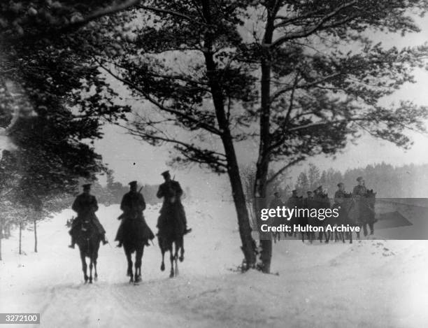 Russian cossacks riding through a forest.