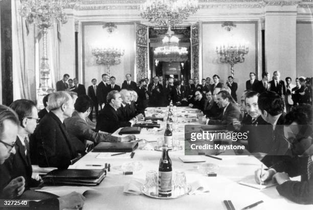 American President Richard Nixon sits opposite Leonid Brezhnev and other Soviet leaders at a conference in Moscow.