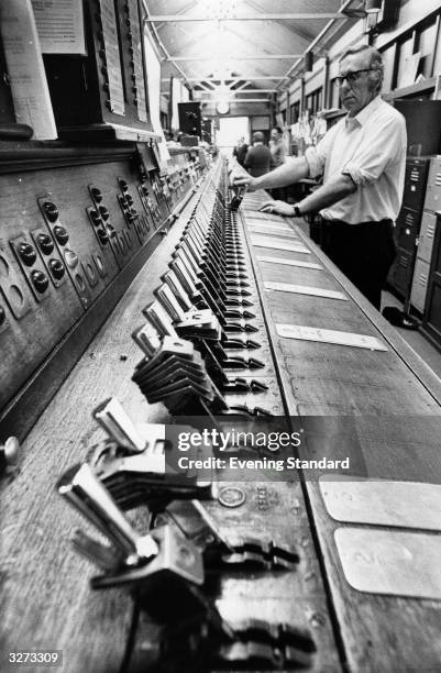 Signal man at work on levers in the old signal box at London Bridge Station.
