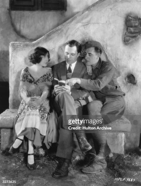 French actress Renee Adoree and her leading man John Gilbert sitting with director King Vidor during the filming of his World War I drama 'The Big...