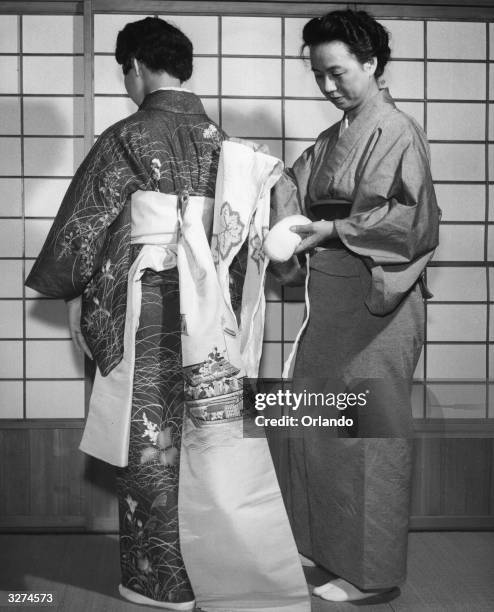 The obi or brightly coloured sash which is part of the Japanese woman's kimono is held in place with a pad.