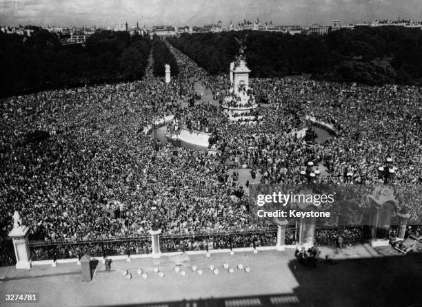 The view which greeted the King from Buckingham Palace on VJ Day. As far as the eye can see jubilant crowds stretch from Queen Victoria's monument...