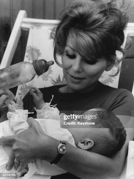 Irina Demick, the Franco-Russian leading lady feeds her baby daughter, Marie Emmanuelle on the terrace of their home.