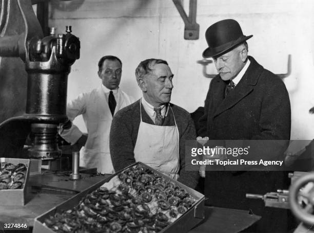 Earl Haig watches the stamping of poppies by ex-servicemen, during a visit to the British Legion poppy factory at Richmond. Haig, born in Edinburgh,...