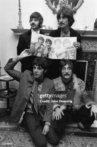 British rock band The Beatles pose with the cover of their new album 'Sergeant Pepper's Lonely Hearts Club Band' at manager Brian Epstein's west...