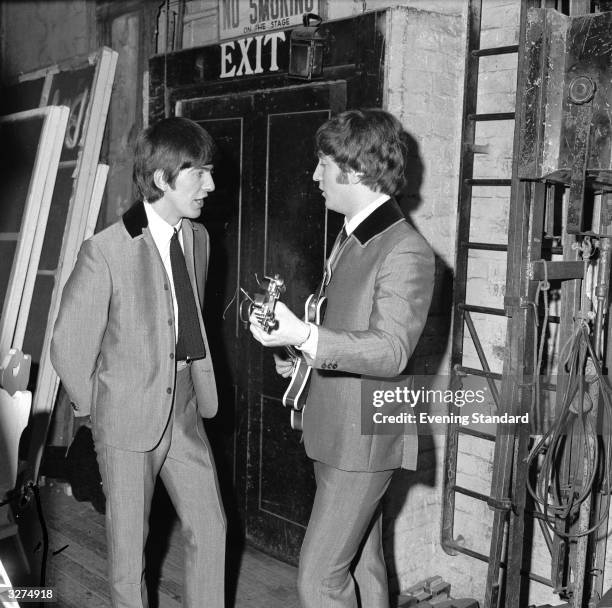 George Harrison and John Lennon of The Beatles have a quick practice backstage.
