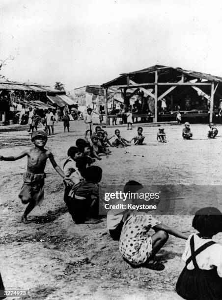 Japanese children incarcerated as prisoners of war play games in the camp on Saipan.