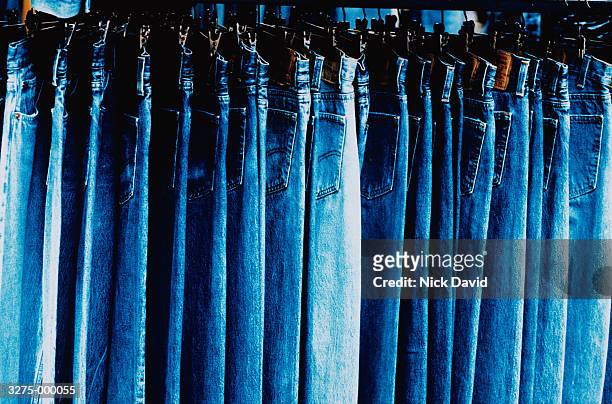 blue jeans hanging in store - levi's stockfoto's en -beelden