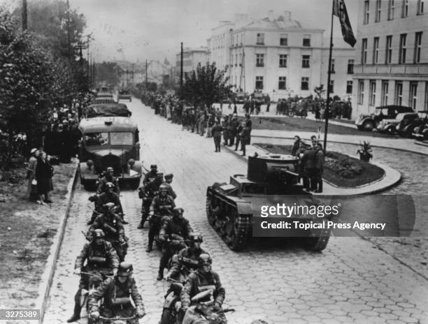 Demarcation line ceremony at Brest-Litovsk, Poland. Red Army armoured cars and a mobile German rifle corps move down the street.