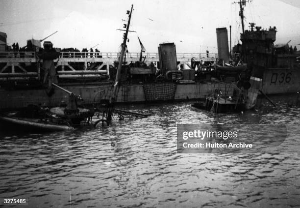 Valorous' is alongside the pier at Dunkirk, next to a trawler which was sunk by a bomb. HMS 'Imogen' is on the far side.