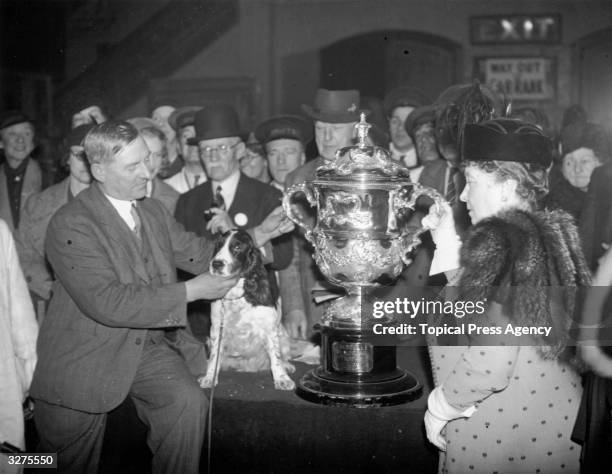 Mrs Cruft presenting the trophy at the Royal Agricultural Hall in London to Mr H S Lloyd whose cocker spaniel 'Exquisite Model Of Ware' was named as...