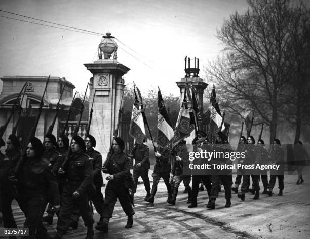 Officers of the French French Forces march off a parade ground at a London barracks with their new colours. The Feat of St Joan had been marked by...