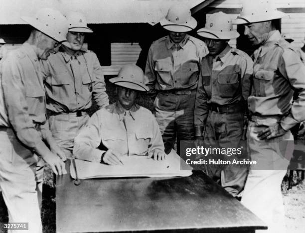 Major General Jonathan Wainwright, ranking field officer under General Douglas MacArthur in the Philippines, seated in his headquarters, discussing...