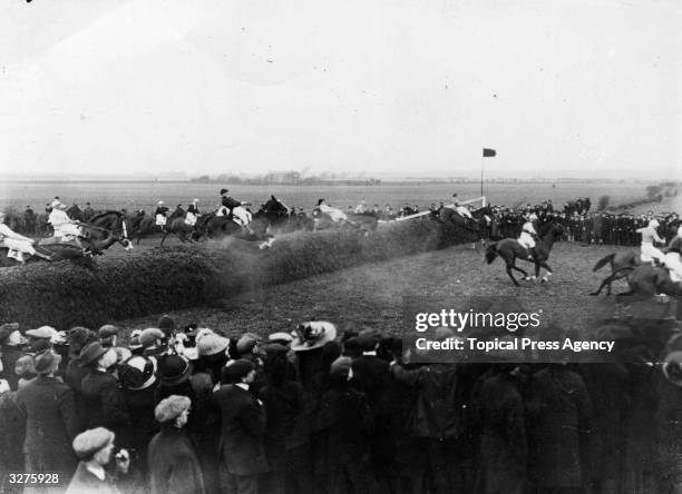 Horses jump an open ditch during the Grand National at Aintree.