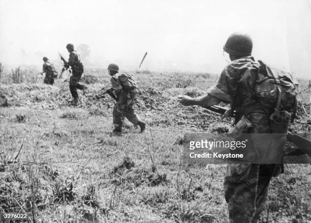 Vietnamese troops advancing on VietMinh rebel positions during the Dien Bien Phu battle in the Indo-China War.