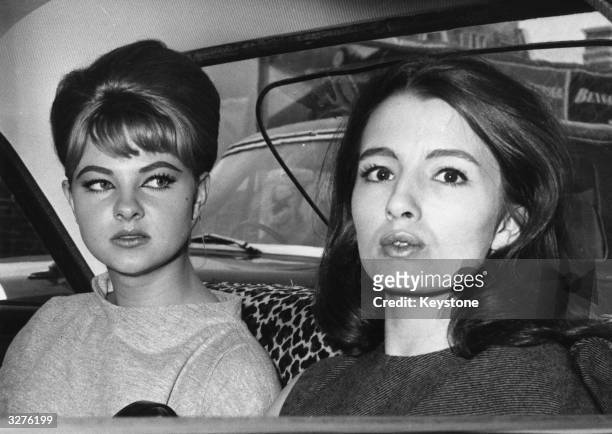 Mandy Rice-Davies who rose to fame for her part in the 'Profumo Affair' sits in a car with Christine Keeler who is also a model and show girl after...