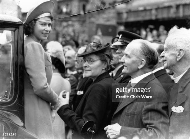 Princess Elizabeth is greeted by crowds as she tours the East End of London on the day after VE Day, 9th May 1945.