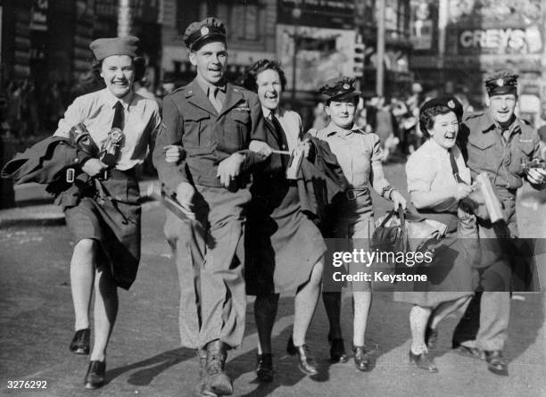 WAAFs link arms with soldiers during the VJ Day celebrations in Piccadilly Circus.