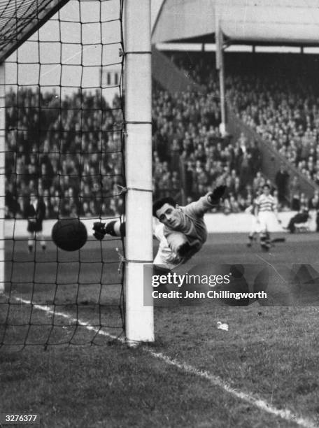 Celtic goalkeeper Miller, fails to keep the ball out of the net during a Glasgow Rangers attack at Ibrox Stadium. Large crowds gather for the matches...