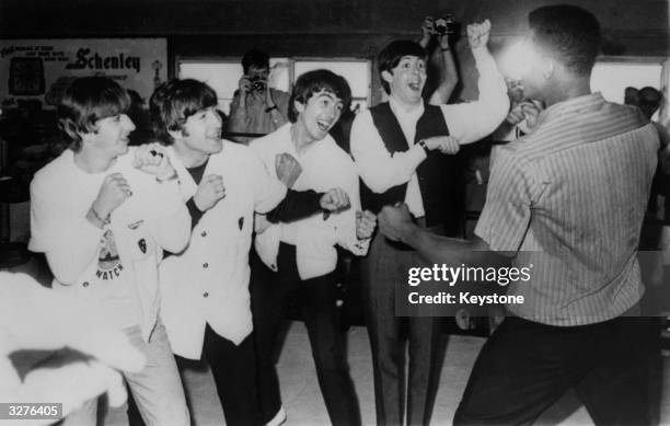 British pop group The Beatles, from left to right; Ringo Starr, John Lennon , George Harrison and Paul McCartney; in the ring with champion American...