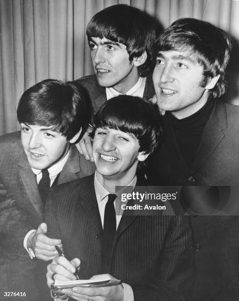 The Beatles signing autographs at their first press reception in Miami.