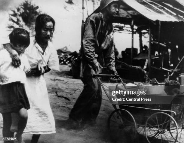 An American soldier helps a Japanese family move to an internment camp on Saipan.