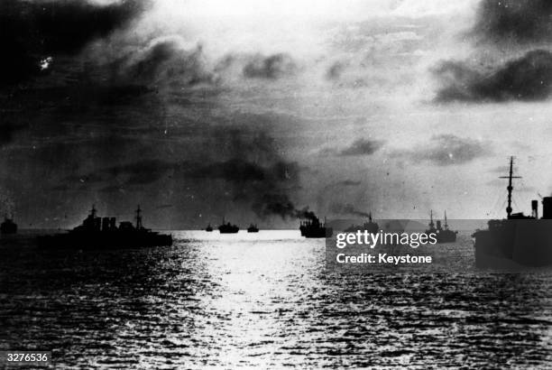 Convoy with British Navy escort at sunset.