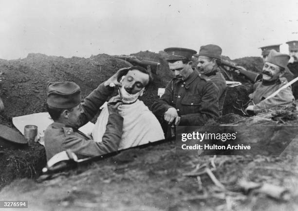 Soldier gets a shave in a Serbian trench.